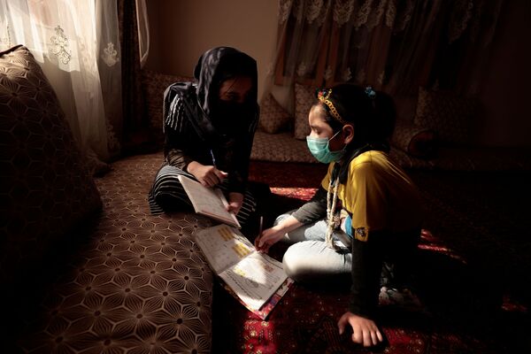 17岁的萨哈尔正在帮助10岁的妹妹哈迪完成家庭作业。 - 俄罗斯卫星通讯社