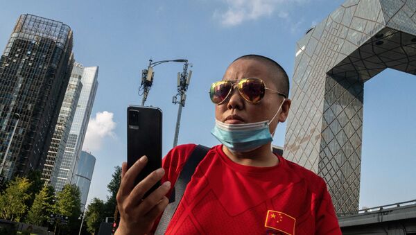 Женщина со сматрфоном в Пекине на фоне вышек 5G - 俄罗斯卫星通讯社