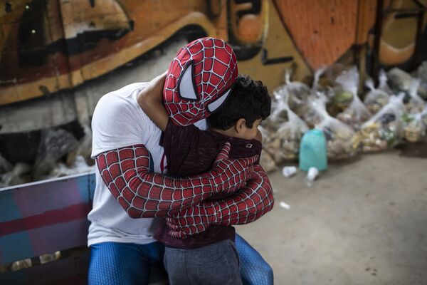 巴西里約熱內盧，一名扮成蜘蛛俠的志願者正在擁抱一個孩子。 - 俄羅斯衛星通訊社