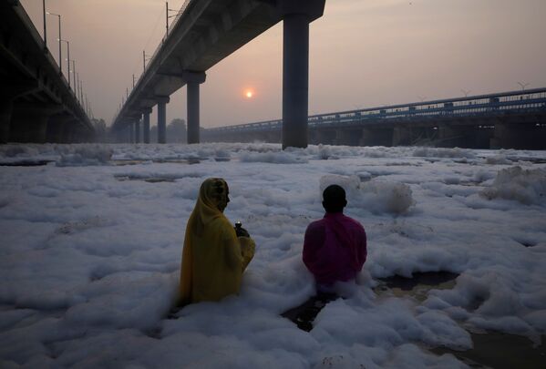 一对印度夫妇在有毒泡沫覆盖的亚穆纳河中祭拜克哈特普迦节太阳神。 - 俄罗斯卫星通讯社