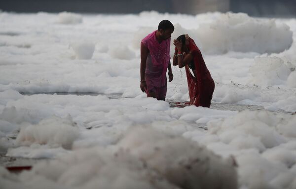 一對印度夫婦在有毒泡沫覆蓋的亞穆納河中祭拜克哈特普迦節太陽神。 - 俄羅斯衛星通訊社