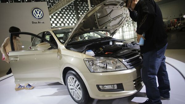 In this Oct. 3, 2013 photo, visitors look at a new Santana of Volkswagen - 俄罗斯卫星通讯社