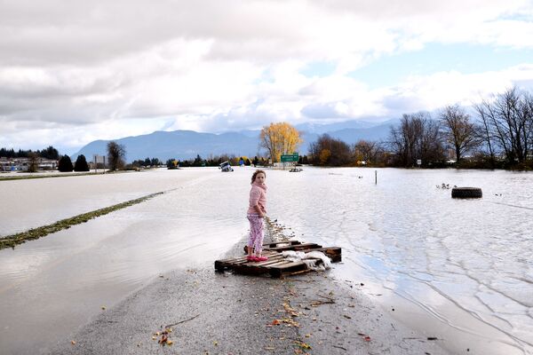 小女孩在大水淹沒的街道上。  - 俄羅斯衛星通訊社