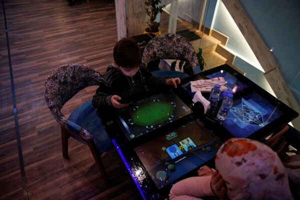 摩苏尔一家餐厅里，一个小男孩正在智能桌子上玩耍。 - 俄罗斯卫星通讯社