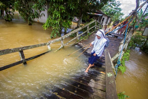 印尼洪水过后，一个小姑娘走在被洪水毁坏的桥上。 - 俄罗斯卫星通讯社