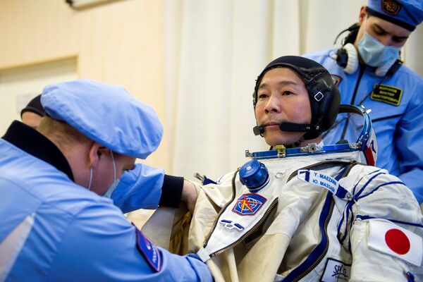 日本富豪前泽友作在“联盟”号飞船旁做前往国际空间站的飞行前准备。 - 俄罗斯卫星通讯社