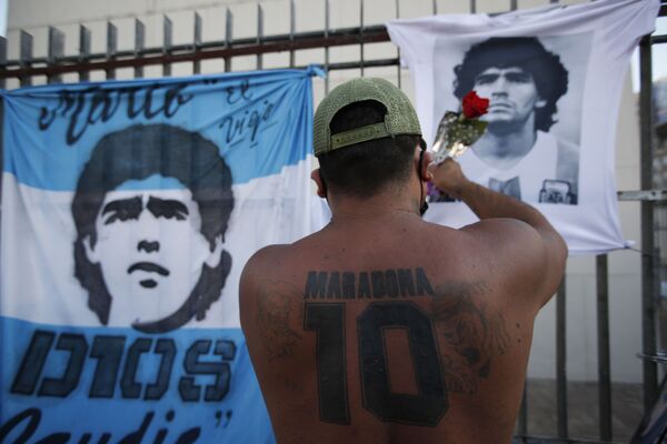 布宜諾斯艾利斯，一個球迷向印有已故球星馬拉多納頭像的汗衫獻花。 - 俄羅斯衛星通訊社