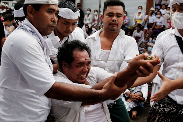 在印度尼西亞巴釐島舉行的眾神聚會（Ngerebong）儀式上，一名印度教徒試圖用傳統的克里斯短劍刺傷自己。 - 俄羅斯衛星通訊社