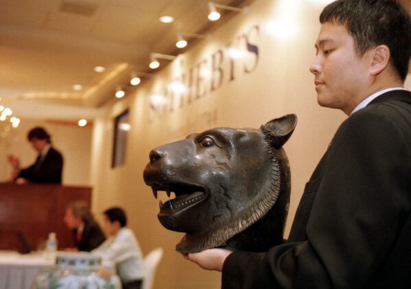 蘇富比的一名員工在香港中國藝術品拍賣會上手持一個青銅虎頭。 - 俄羅斯衛星通訊社