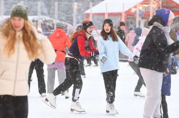 下雪时，人们在莫斯科古姆百货商场滑冰场里滑冰。 - 俄罗斯卫星通讯社