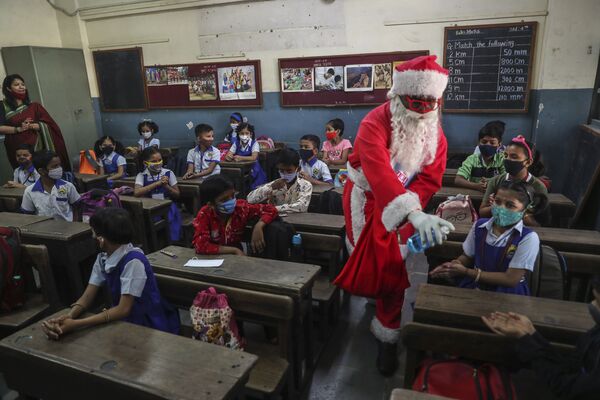孟買，衛生員扮成聖誕老人在上課前給孩子們的手消毒。 - 俄羅斯衛星通訊社