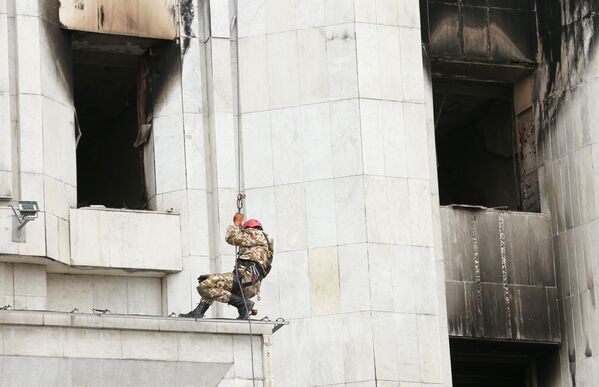 阿拉木圖，一個工人正在修復被大火燒毀的阿基馬特大樓 - 俄羅斯衛星通訊社
