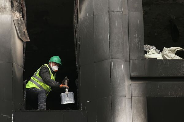 阿拉木圖，一個工人正在修復被大火燒毀的阿基馬特大樓（地方政府）。 - 俄羅斯衛星通訊社