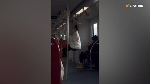  俄罗斯女子将头发系在地铁车厢扶手上“练功” - 俄罗斯卫星通讯社