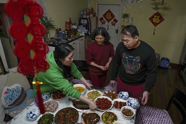 山東省的一名女子及其丈夫正在準備和自己的朋友在家中聚會的菜餚，由於北京在農歷新年前疫情的出行限制他們決定不返鄉。 - 俄羅斯衛星通訊社