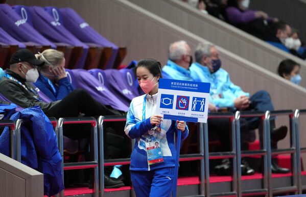 北京冬奥会志愿者手持“保持间距和佩戴口罩”提示牌。 - 俄罗斯卫星通讯社