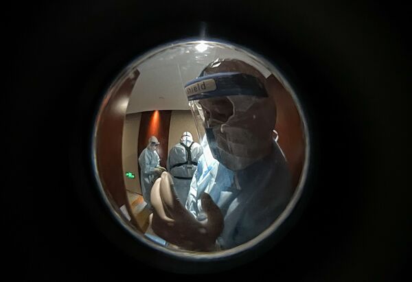 穿著防護服的醫務人員在北京一座酒店的新冠陽性記者隔離房間附近。 - 俄羅斯衛星通訊社