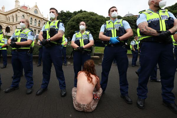 新西蘭惠靈頓爆發的反對新冠疫情限制措施示威活動期間，一名女性坐在議會廣場的警察面前，2022年2月10日。 - 俄羅斯衛星通訊社