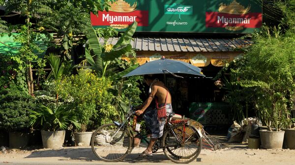 Мужчина на фоне рекламы пива, Янгон, Мьянма - 俄罗斯卫星通讯社