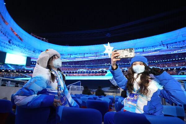 北京冬奥会闭幕式开始举行前，志愿者在国家体育场“鸟巢”拍照留念。 - 俄罗斯卫星通讯社