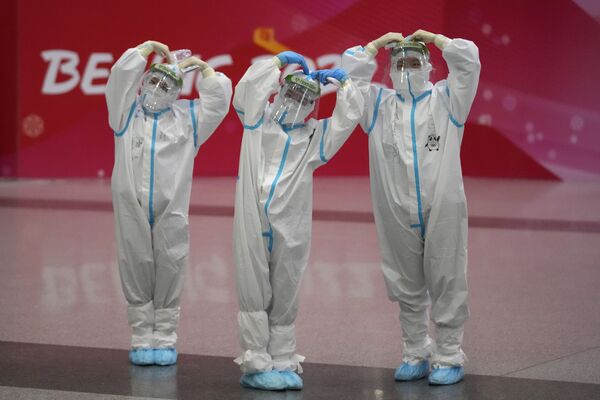 身著防護服的工作人員在北京國際機場內擺拍留念。 - 俄羅斯衛星通訊社
