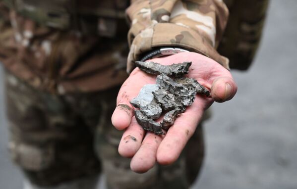 一名士兵在顿涅茨克一住宅楼前展示弹药碎片，该住宅楼在炮击中被毁。 - 俄罗斯卫星通讯社