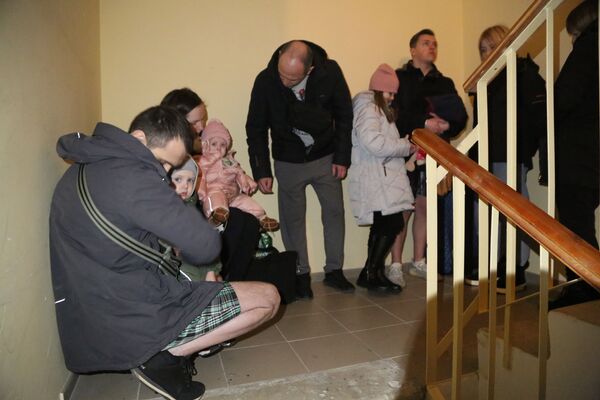 顿涅茨克的居民们在住宅楼入口处的楼梯上躲避炮击。 - 俄罗斯卫星通讯社