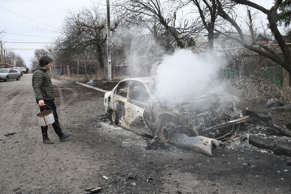 顿涅茨克，一名男子站在一辆燃烧的汽车旁边。 - 俄罗斯卫星通讯社