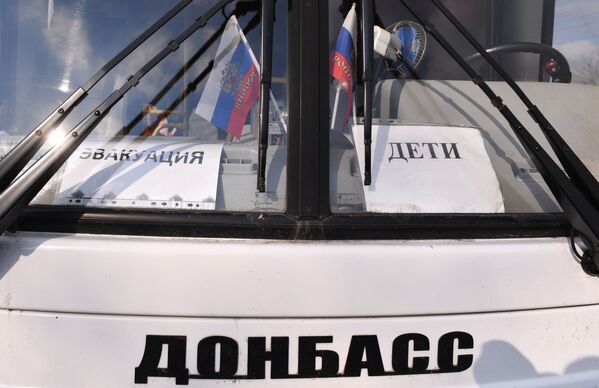 疏散人员援助站附近标有“疏散”和“儿童”标志的巴士。 - 俄罗斯卫星通讯社