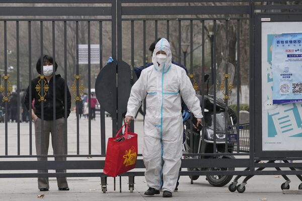 北京某封控区，身着防护服的工作人员从居民手中接过一袋物品。 - 俄罗斯卫星通讯社