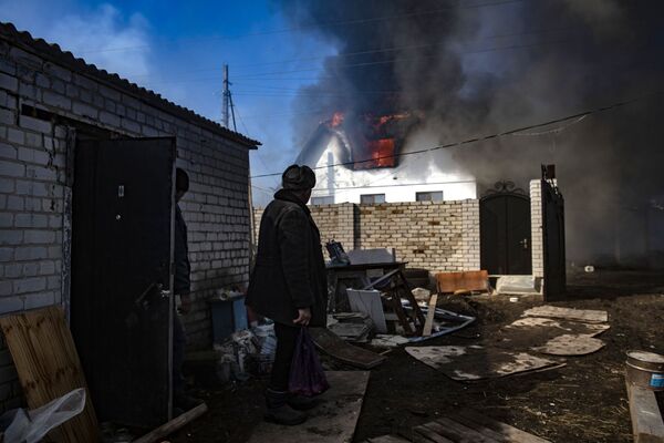 卢甘斯克瓦尔瓦罗夫卡村的村民看向一栋着火的房子。 - 俄罗斯卫星通讯社