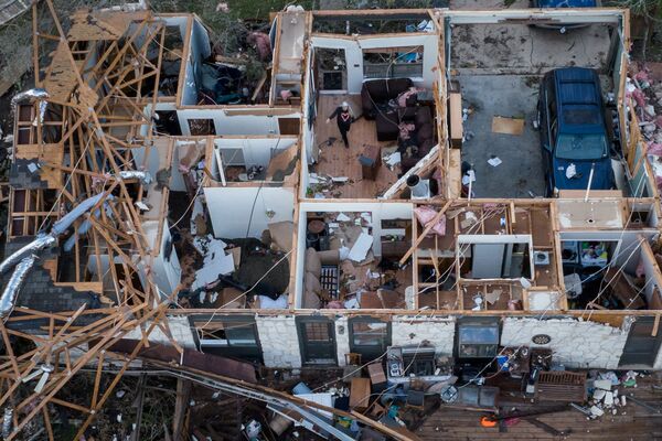 德克薩斯州龍捲風過後，一名婦女走過被毀壞的房子。 - 俄羅斯衛星通訊社