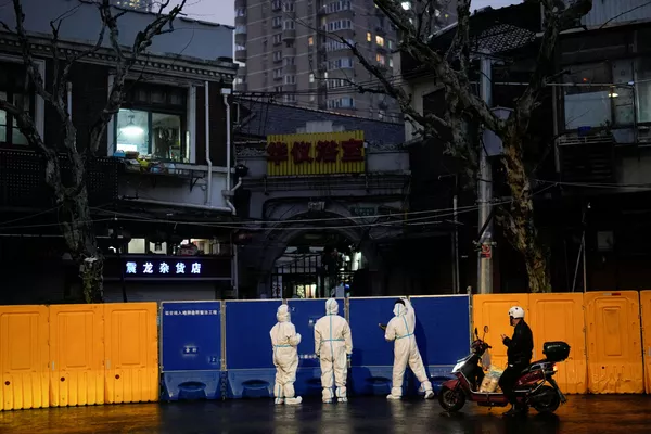 身穿防護服的醫務人員站在封控區域的圍擋前，2022年3月25日。 - 俄羅斯衛星通訊社