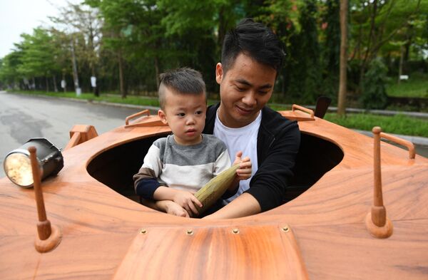 越南北寧省，坐在木制坦克里的父子倆。 - 俄羅斯衛星通訊社