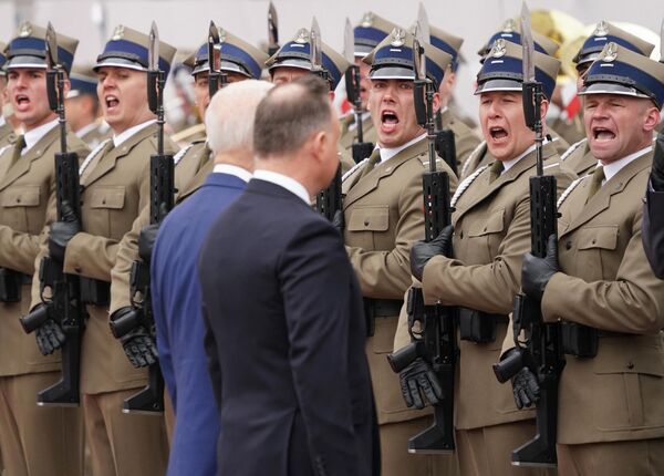 美国总统拜登(前左)访问波兰，和波兰总统杜达检阅仪仗队，2022年3月26日。 - 俄罗斯卫星通讯社