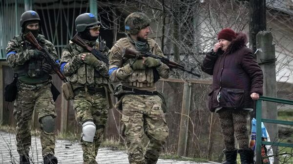 Женщина смотрит на украинских военнослужащих в Буче, Украина - 俄羅斯衛星通訊社