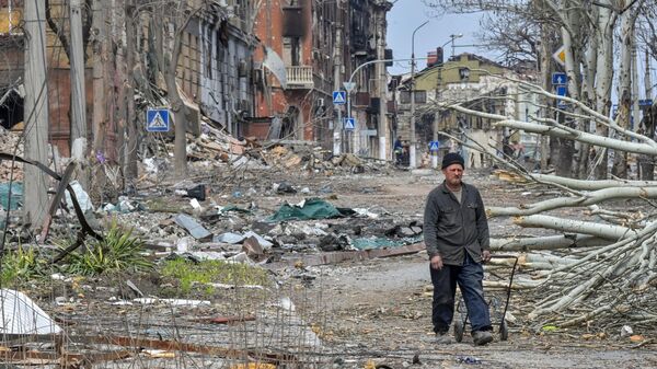 馬里烏波爾居民走在街上被毀壞的建築物附近。 - 俄羅斯衛星通訊社