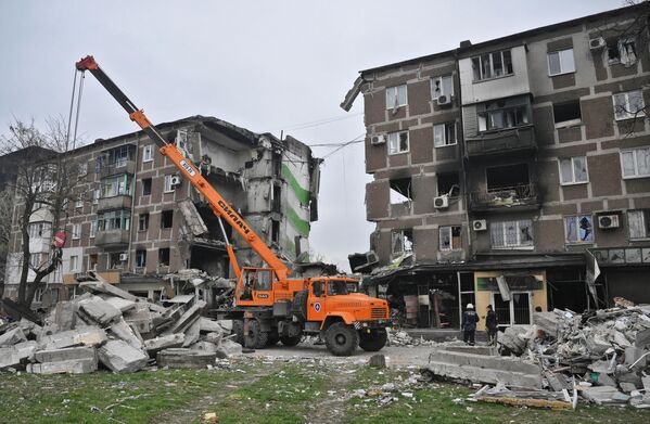 頓涅茨克人民共和國緊急情況部的工作人員清理馬里烏波爾市被毀建築附近的瓦礫。 - 俄羅斯衛星通訊社