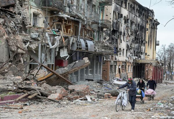 馬里烏波爾居民走在街上被毀壞的建築物附近。 - 俄羅斯衛星通訊社