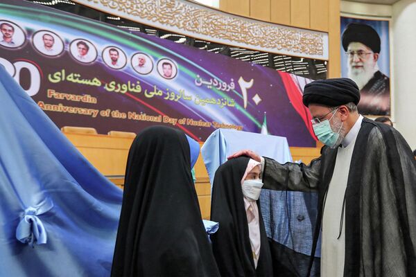 伊朗总统莱希（右）出席在德黑兰举行的“国家核技术日”的活动中和一个小女孩打招呼。 - 俄罗斯卫星通讯社