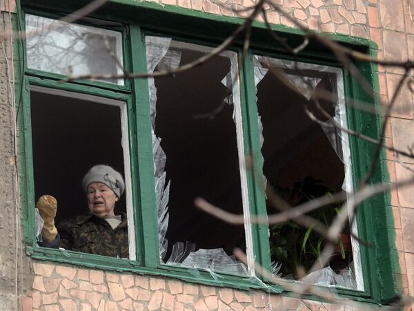戈爾洛夫卡市居民在家中清掃遭炮擊損毀的玻璃碎片。 - 俄羅斯衛星通訊社