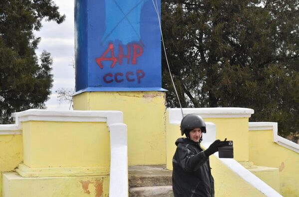 媒体记者在喷有“DPR USSR”字样的纪念碑前拍摄。 - 俄罗斯卫星通讯社