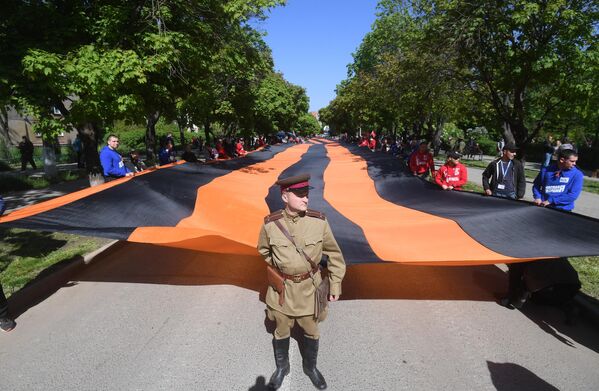 在紀念偉大衛國戰爭勝利 77 週年的節慶活動中手持 300 米長的聖喬治絲帶進行遊行的人們。 - 俄羅斯衛星通訊社