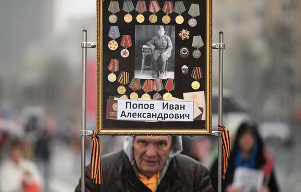 俄民众手持参加过伟大的卫国战争的亲属的肖像，参加在莫斯科举行的“不朽军团”游行。 - 俄罗斯卫星通讯社