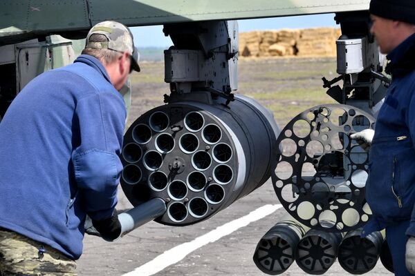 一名机械师在野战机场里将一枚非制导导弹(NAR)装入俄罗斯空天军一架卡-52攻击直升机上，该直升机参加了哈尔科夫方向的特别军事行动。 - 俄罗斯卫星通讯社