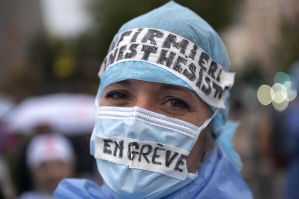 2021年11月25日，在法国南部马赛的蒂莫内医院前，一名麻醉护士戴着写有“罢工”字样的口罩参加示威，呼吁对其职业更好的认可并希望增加工资。 - 俄罗斯卫星通讯社
