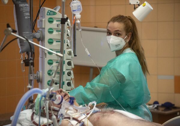 2022 年1月26日，一名护士在布拉格综合大学医院的重症监护病房治疗一名感染新冠病毒的患者。布拉格一家医院治疗新冠肺炎患者的医生已经脱去了曾经的强制性防护服，声称紧贴袖子的细菌实际上提高了死亡率。 （Michal Cizek / 法新社摄） - 俄罗斯卫星通讯社