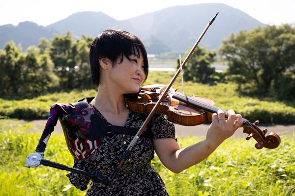 在这张拍摄于2021年8月28日的照片中，日本音乐家，兼一名合格的护士和前残奥会游泳运动员伊藤真奈美，在静冈的一次拍摄期间用她的假肢拉小提琴。这位日本音乐家在东京残奥会开幕式上以她简短但抢眼的表演令全国观众痴迷，然而拉小提琴甚至不是她的日常工作。（岩村由纪/法新社摄） - 俄罗斯卫星通讯社