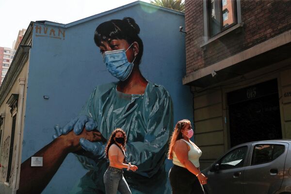 2022年2月11日，幾名女性走過聖地亞哥一名護士的壁畫。智利護理協會 (FENASENF) 匯集了來自公立醫院的專業人士，希望表彰並強調護理專業人士在疫情期間所做的重要工作。 - 俄羅斯衛星通訊社