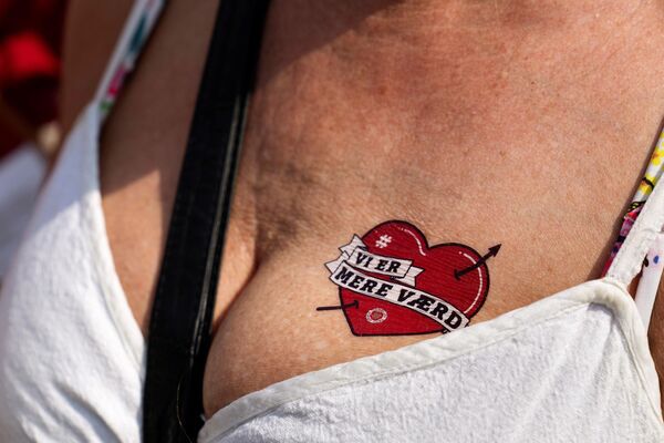 2021年6月19日，丹麦护士在哥本哈根克里斯蒂安堡宫前示威要求提高工资。一名护士胸前的假纹身上写着“我们更有价值”。丹麦有5000名护士罢工，以此要求提高工资。 - 俄罗斯卫星通讯社